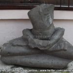 Ruined Tirthankar idol in padmasana - Jain Museum